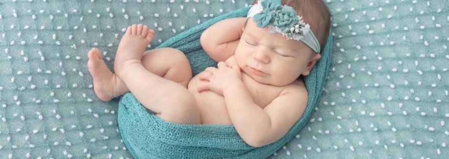 newborn photography, newborn girl swaddled in a dusty teal wrap, dusty teal newborn floral headband, dusty teal newborn blanket