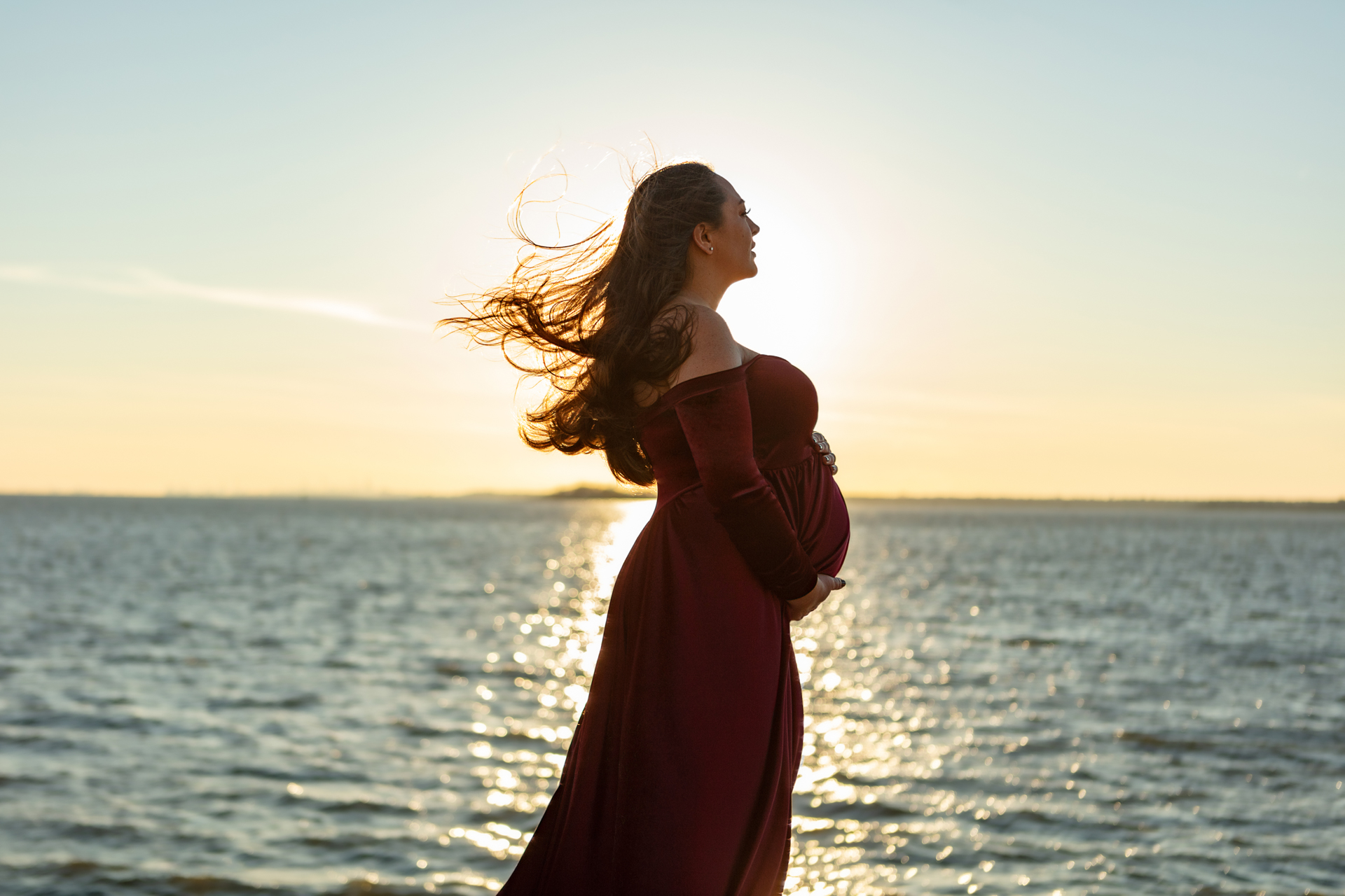 gorgeous golden hour photo of a pregnant mother to be looking out at the water; Looking Up Photography