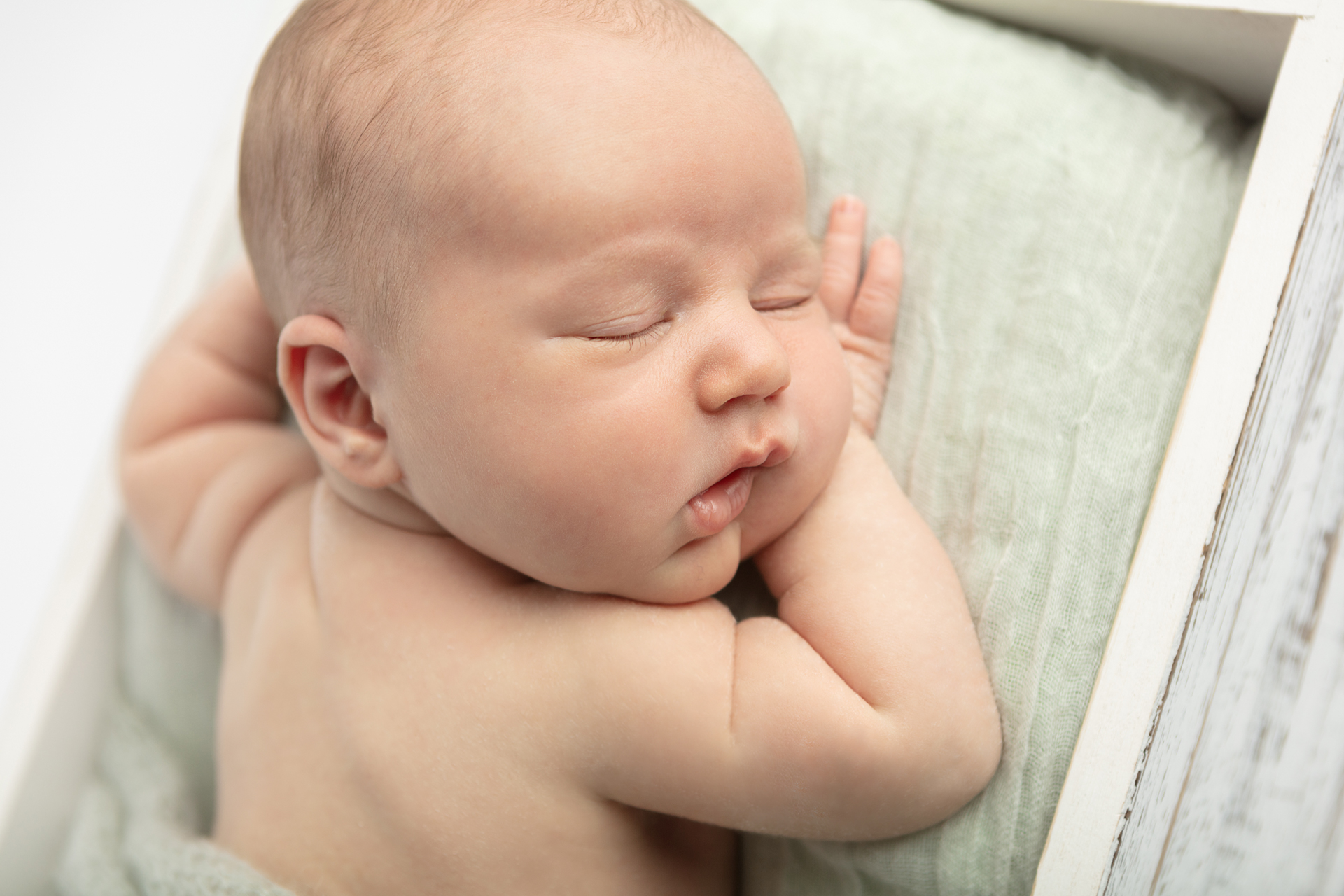 Connecticut newborn photography; newborn boy with his face on his hand; Looking Up Photography