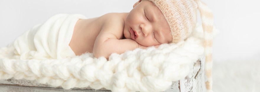 newborn baby boy asleep on his arms with his mouth slightly open; Karen Kahn